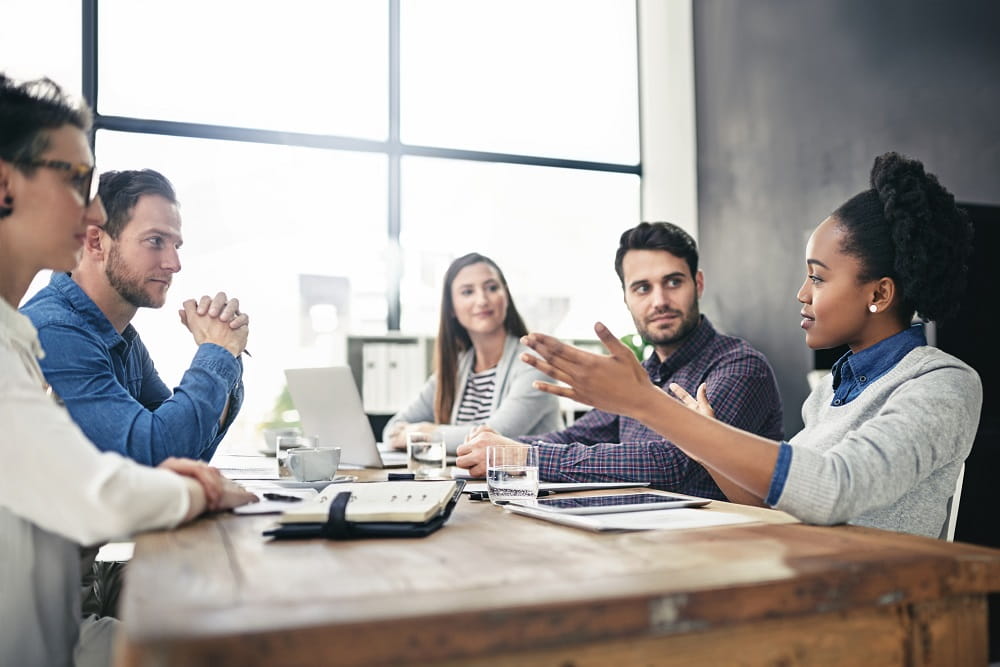 Flere prater sammen rundt bord 