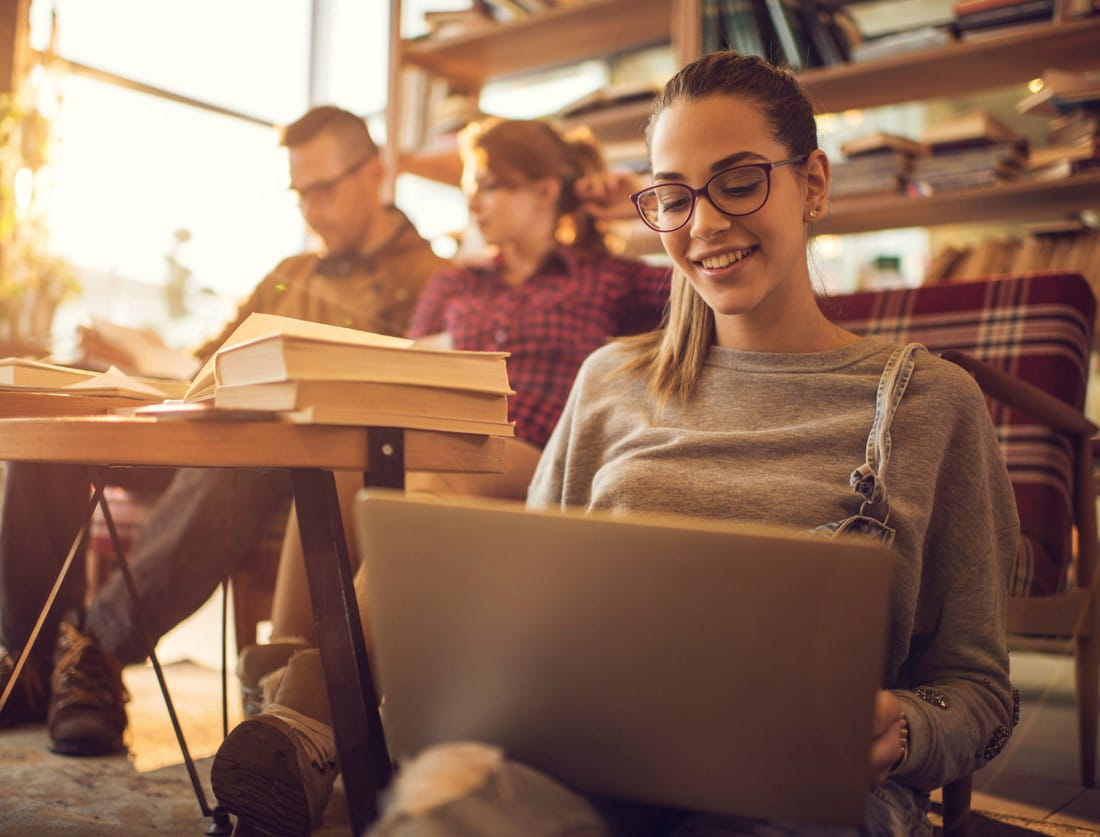 Smilende dame på gulvet med pc